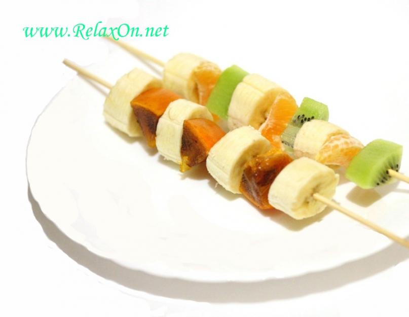 Canapés de fruits en brochettes pour une occasion festive.  Petits canapés aux agrumes orange vif.  Canapé aux fruits de pastèque et de mangue